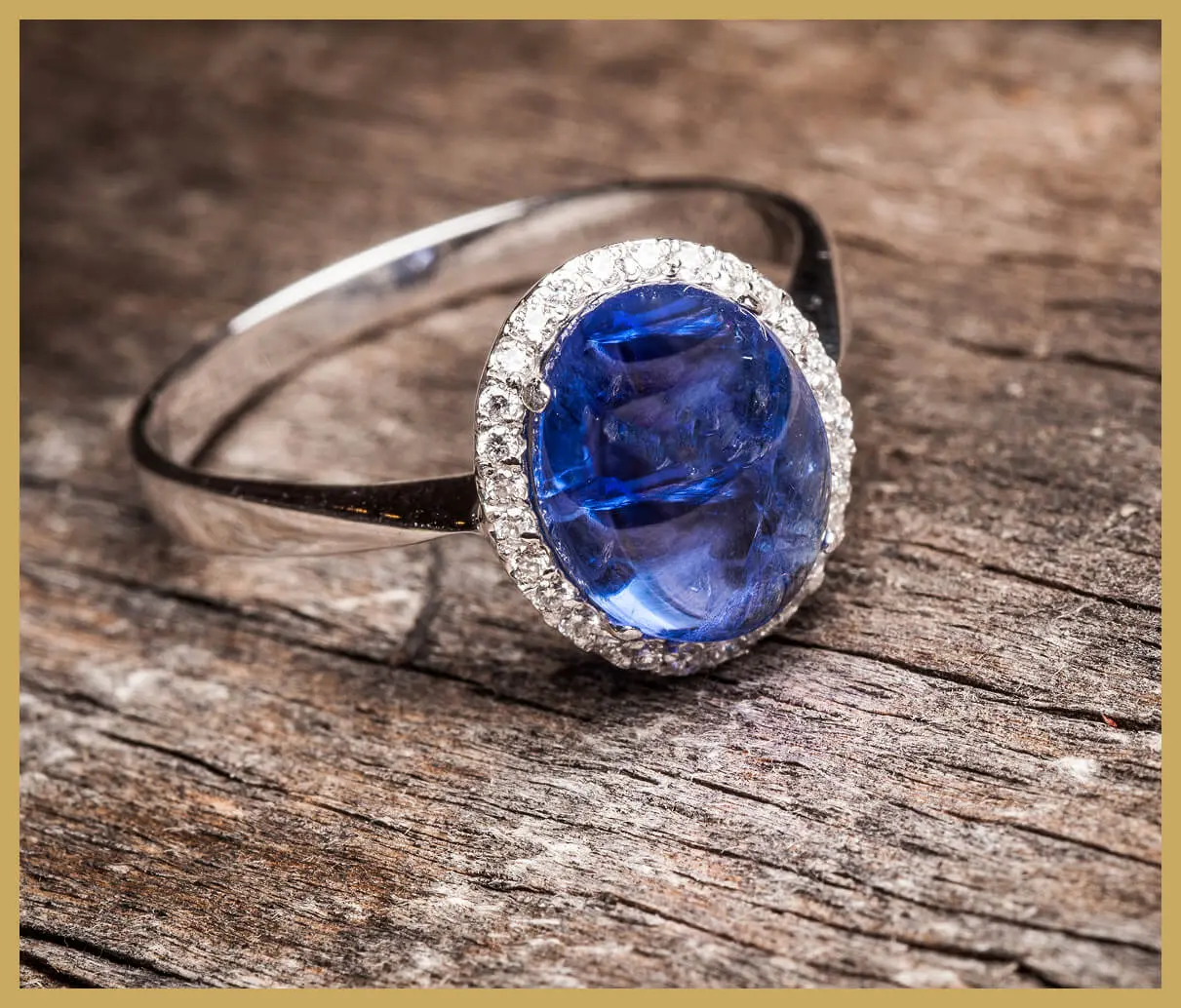 Silver ring with blue gemstone on wood.